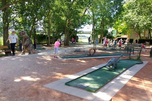 Kinderen spelen een spelletje minigolf tussen de dino's